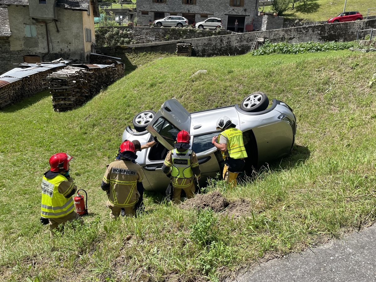 Feuerwehrleute befreien die eingeklemmte Frau aus dem auf der Seite liegenden Auto.