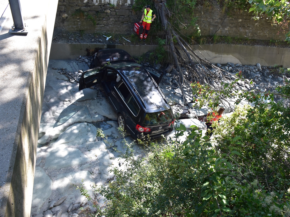 Das im trockenen Bachbett auf den Rädern stehende total beschädigte Auto.