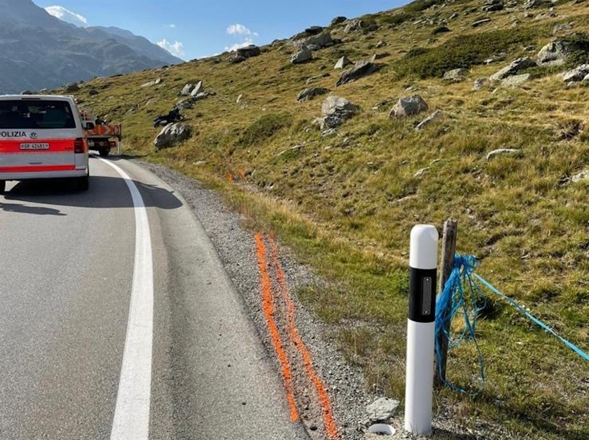 Am rechten Fahrbahnrand ist die Fahrspur des Motorrades mit einem orangen Spray eingezeichnet. Auf der Fahrbahn stehen ein Patrouillenfahrzeug der Polizei sowie ein Einsatzfahrzeug des Tiefbauamtes. Daneben in der Böschung das Motorrad.