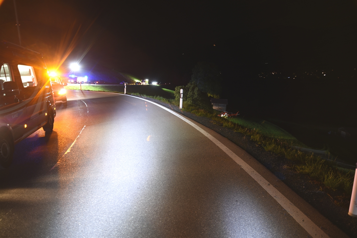Blick über den Strassenrand, Rettungsfahrzeuge im Dunkeln