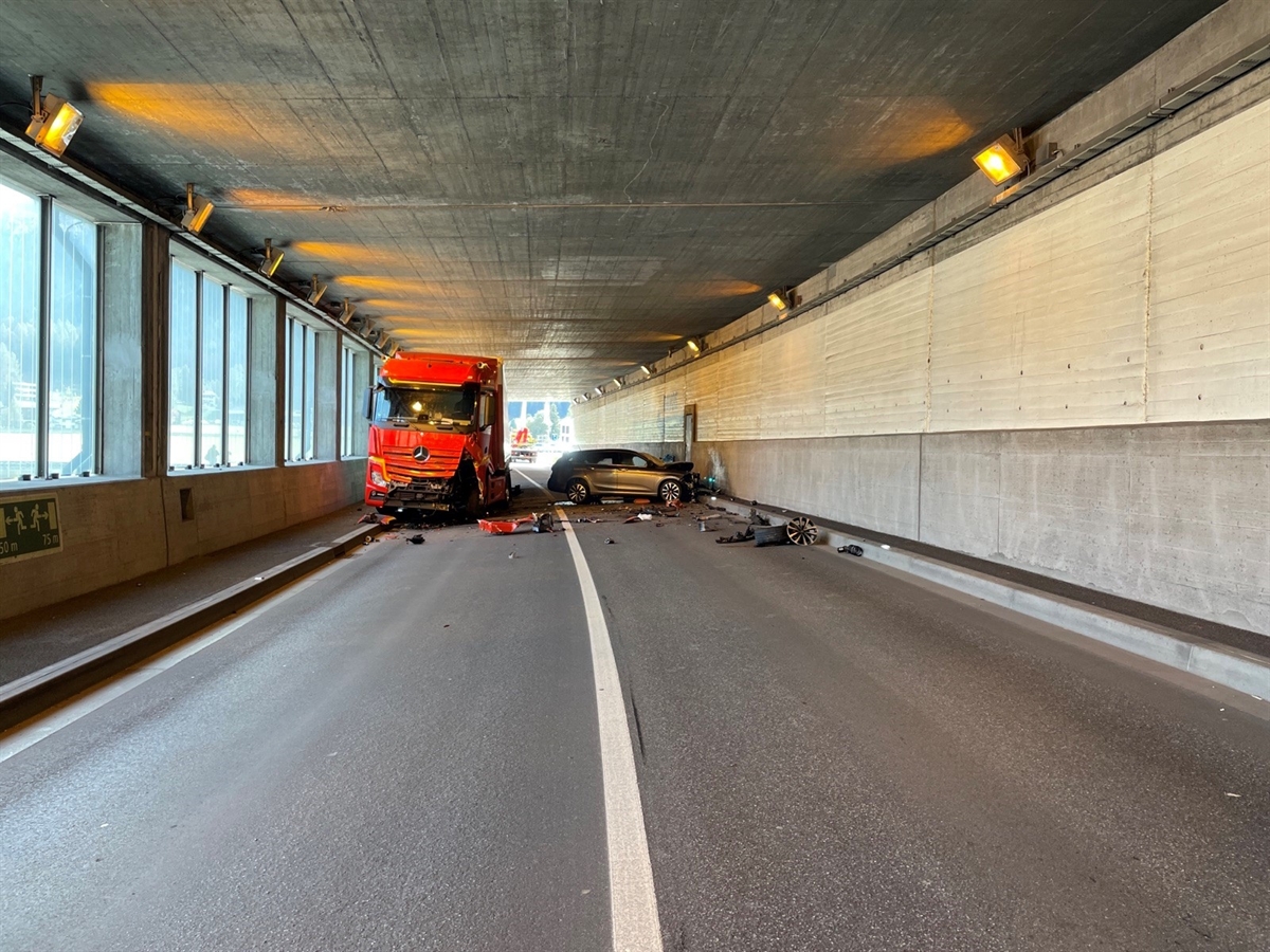 Links die mit Glas verkleidete Aussenwand der Galerie. Rechts halbwegs auf dem Trottoir das Sattelmotorfahrzeug von vorne und weiter rechts das total beschädigte Auto. 