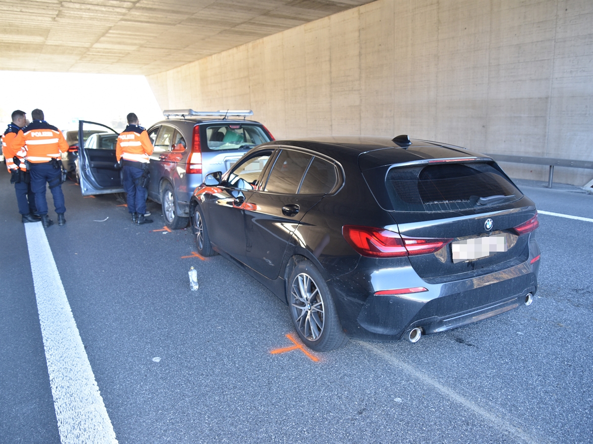 Drei Polizisten stehen neben den vier Autos, die in einander aufgefahren sind.