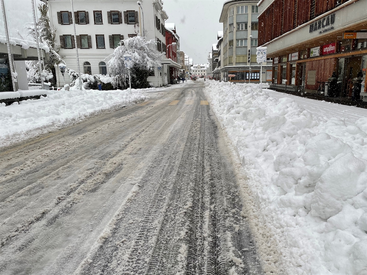 Die von Gebäuden umgebene verschneite Strasse.