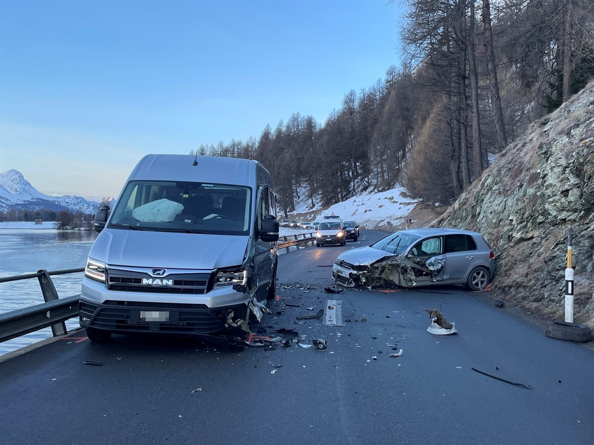 Rechts ein frontal und seitlich links stark beschädigtes Auto. Links das weitere stark beschädigte Fahrzeug. Links davon der Silvaplanersee.