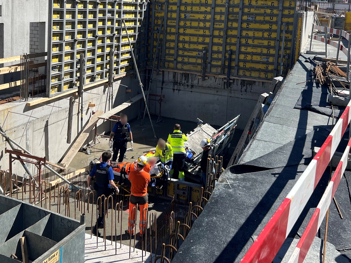 Die Baustelle mit dem Schalungsbereich. Auf der Betonplatte betreuen die Einsatzkräfte den verletzten Arbeiter