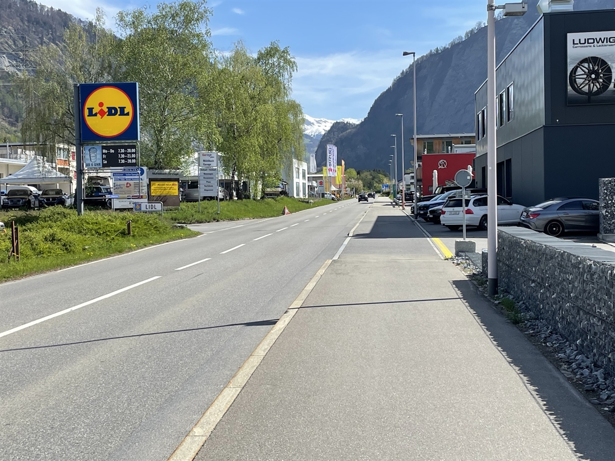 Rechts das Trottoir und links davon die Strasse.