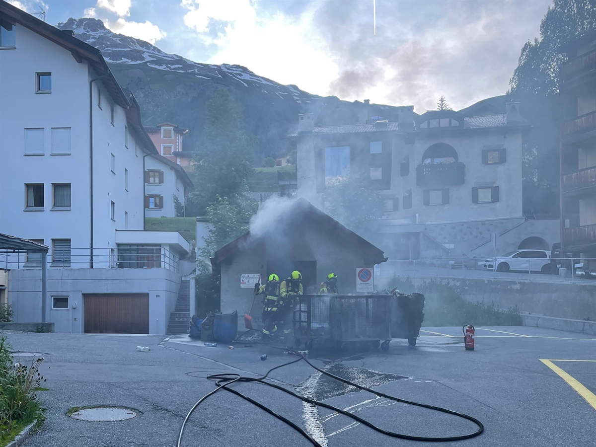 Im Zentrum das Kehrichthaus mit Feuerwehrleuten im Einsatz. Aus dem Kehrichthaus steigt Rauch auf. Im nahen Hintergrund Wohnhäuser.