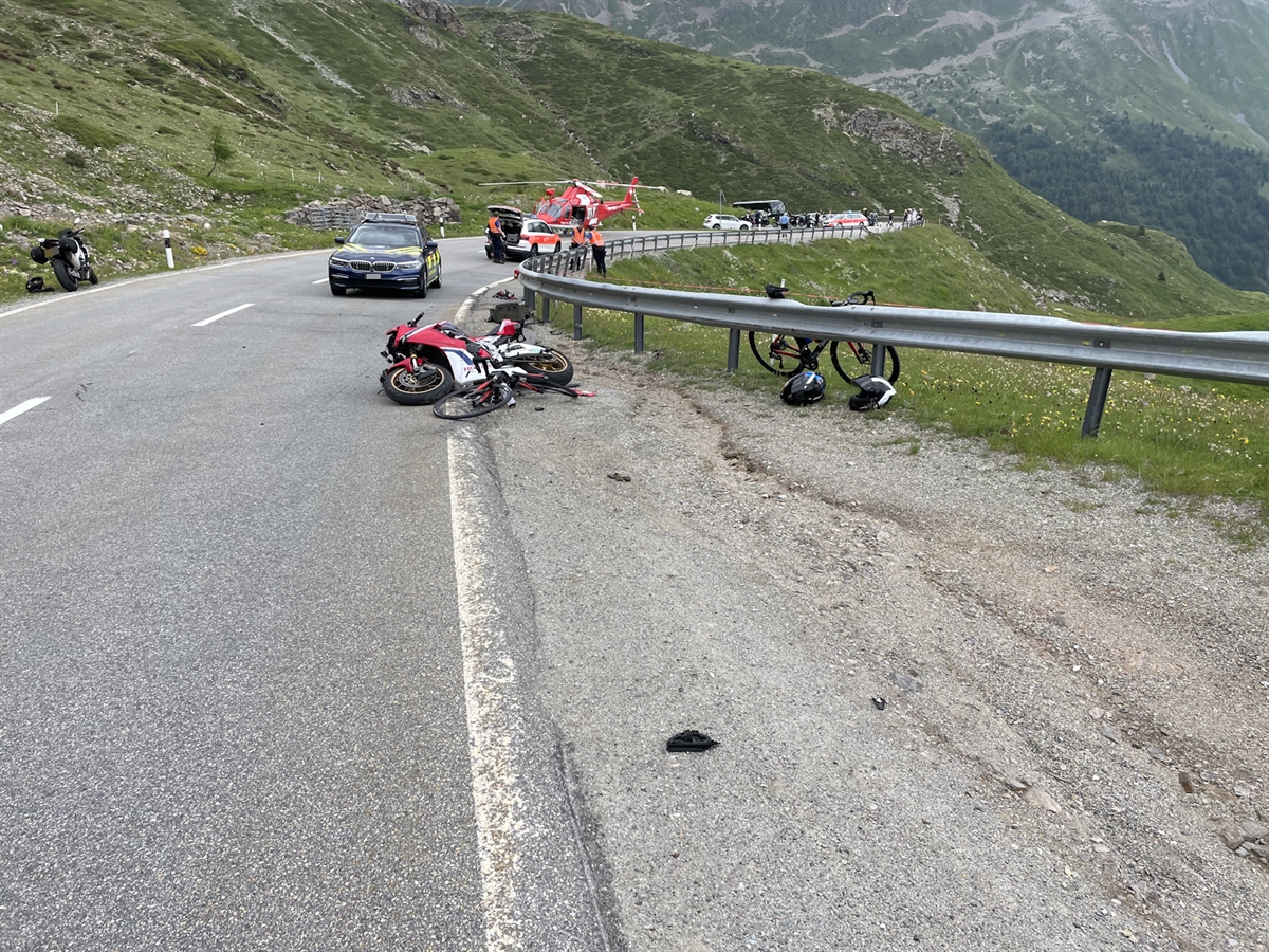 Am rechten Strassenrand liegen die beiden Zweiradfahrzeuge. Hinter diesen stehen Fahrzeuge der Einsatzkräfte sowie der Helikopter der Rega.
