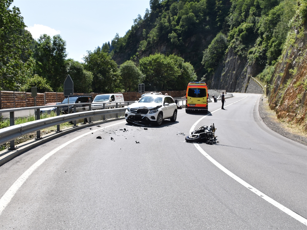 Das Motorrad liegt mitten auf der Fahrbahn. Daneben steht am Strassenrand das entgegen gekommene Auto sowie hinter diesem ein Rettungswagen. Eine Person regelt den Verkehr.
