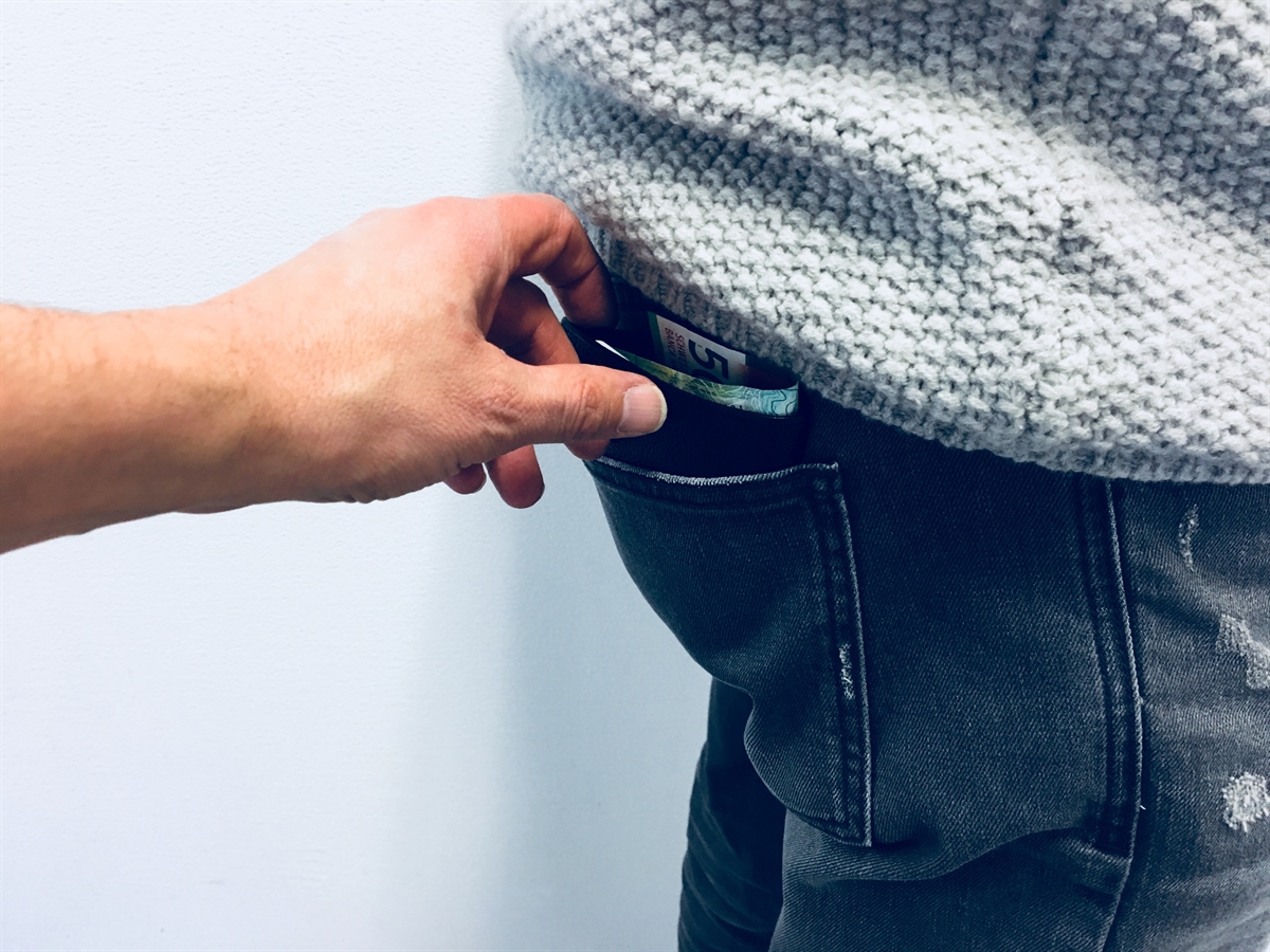Hand entwendet Portemonnaie aus Hosentasche 