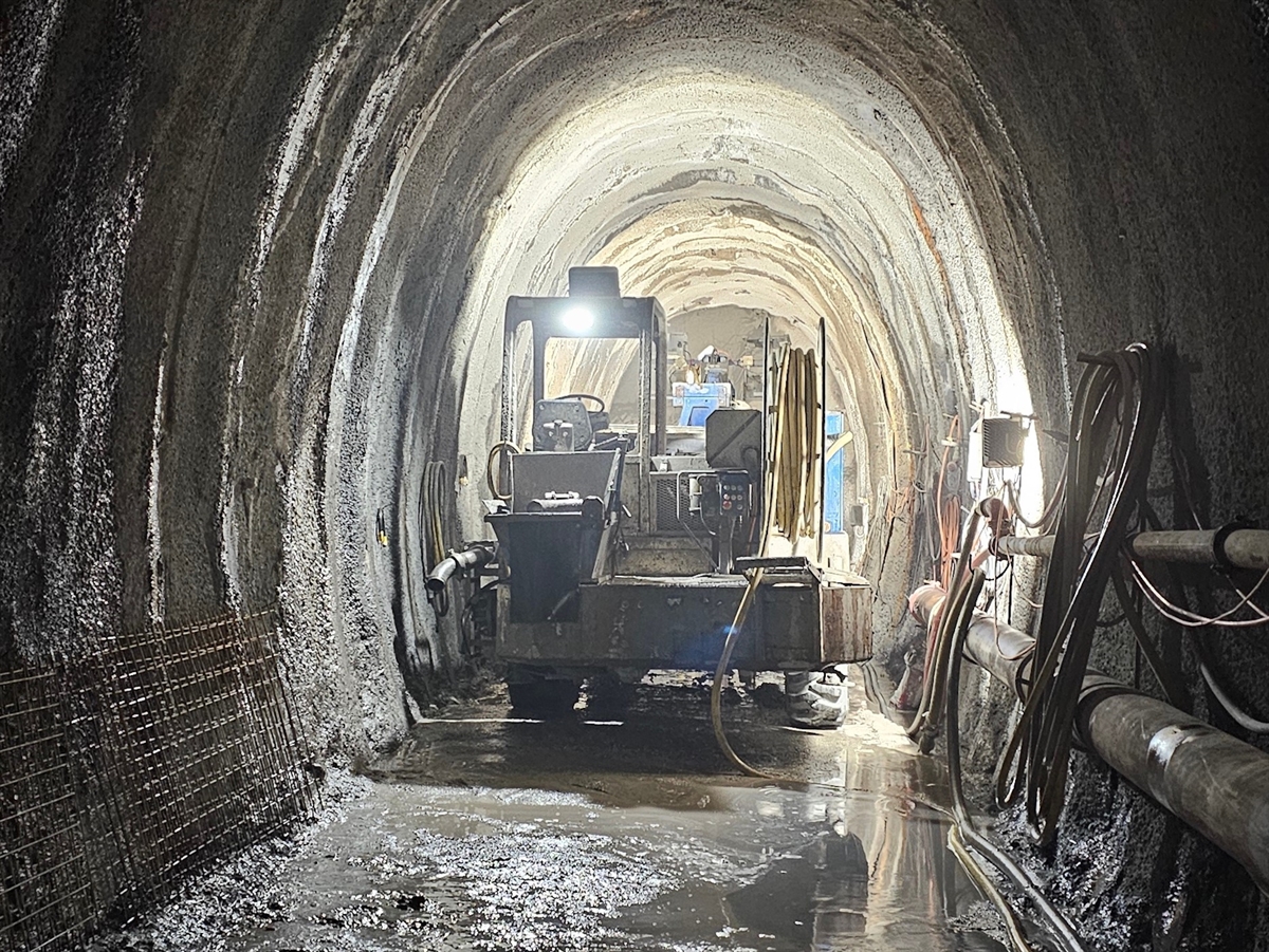 Die Baustelle des Sicherheitsstollens mit der Betonspritzmaschine in Mitten des Stollens.