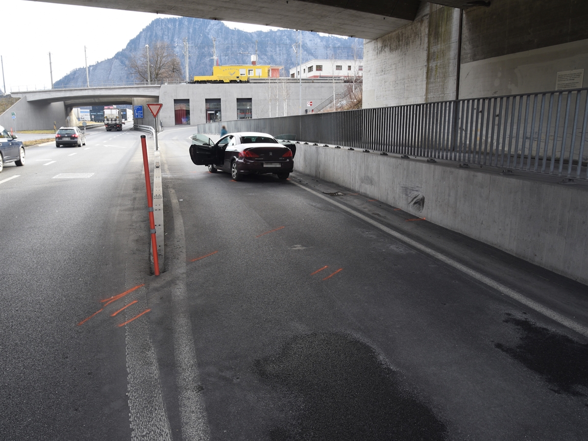 Das Auto steht neben einer Betonmauer. Auf der Fahrbahn sind Spuren eingezeichnet.