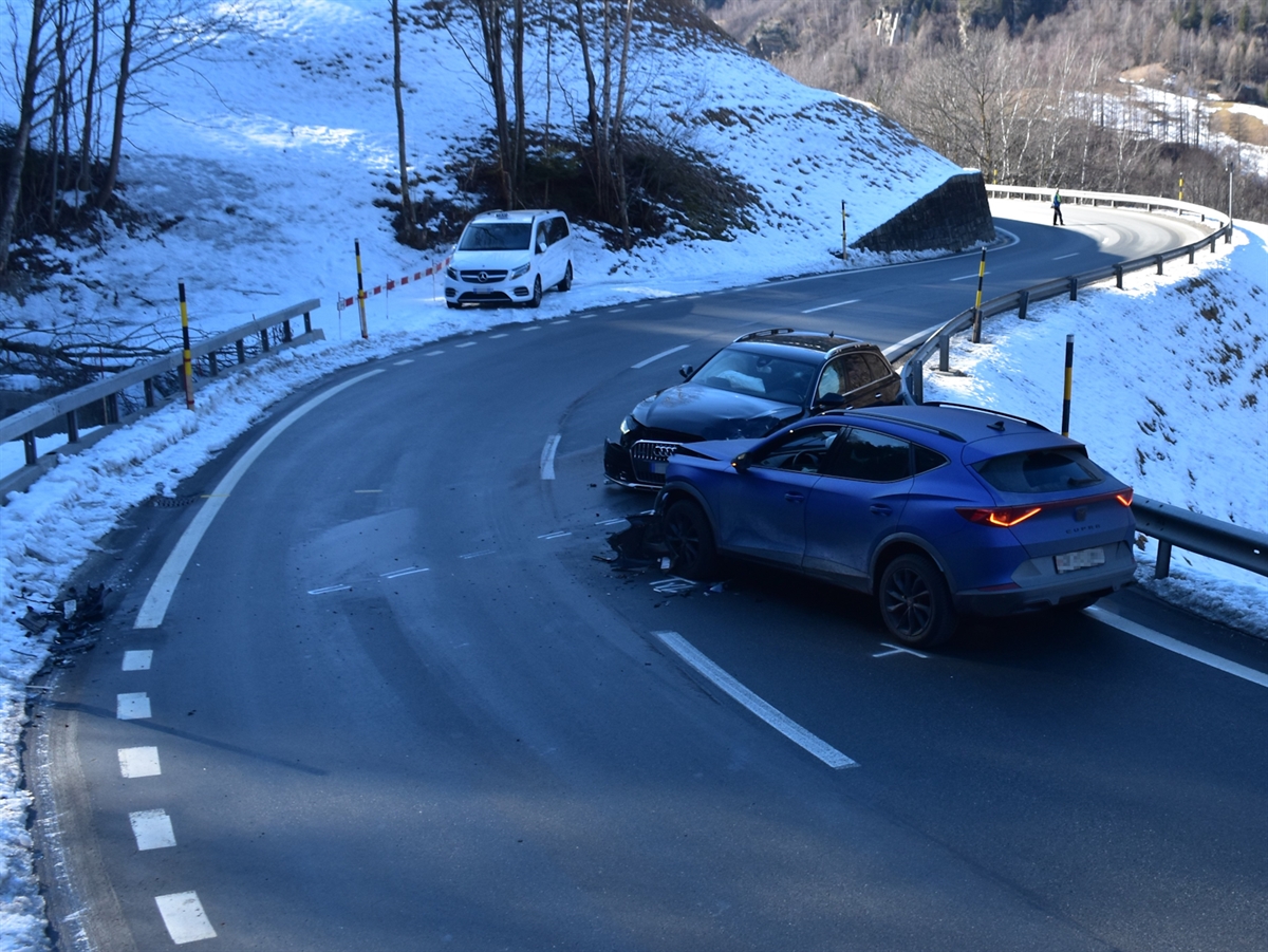 Beide Autos stehen auf der Innenseite der talführenden Fahrspur im 45-Grad Winkel zueinander. Die Kurve liegt im Schatten.