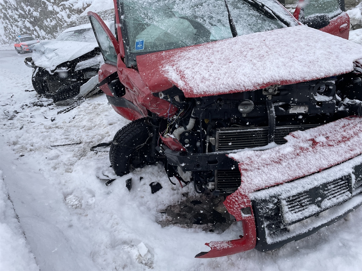Strassenverlauf der schneebedeckten Malojastrasse bei der Unfallstelle. Es sind beide beteiligten Fahrzeuge zu erkennen.