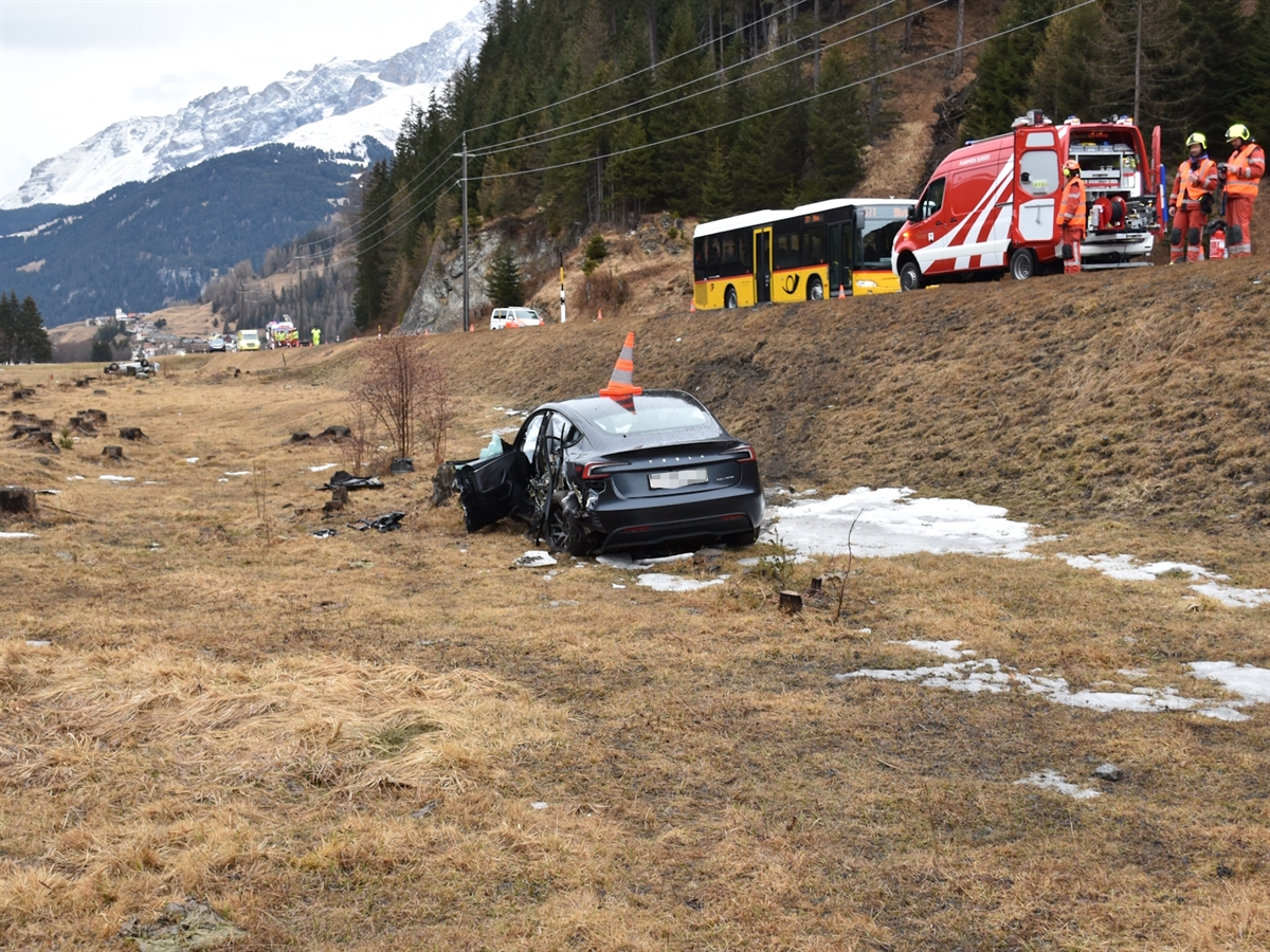 Rechts oben auf der Strasse Einsatzkräfte der Strassenrettung. Links davon unterhalb eines der Unfallautos und in Entfernung das andere Unfallauto.