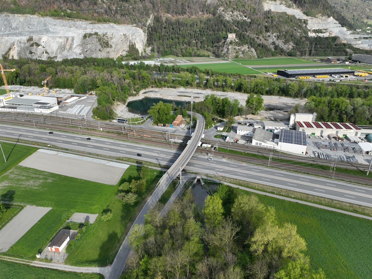 Luftaufnahme auf die Überführung sowie auf die Nord- und die Südspur. Angrenzend Bahngleise sowie Industriegebiet. 