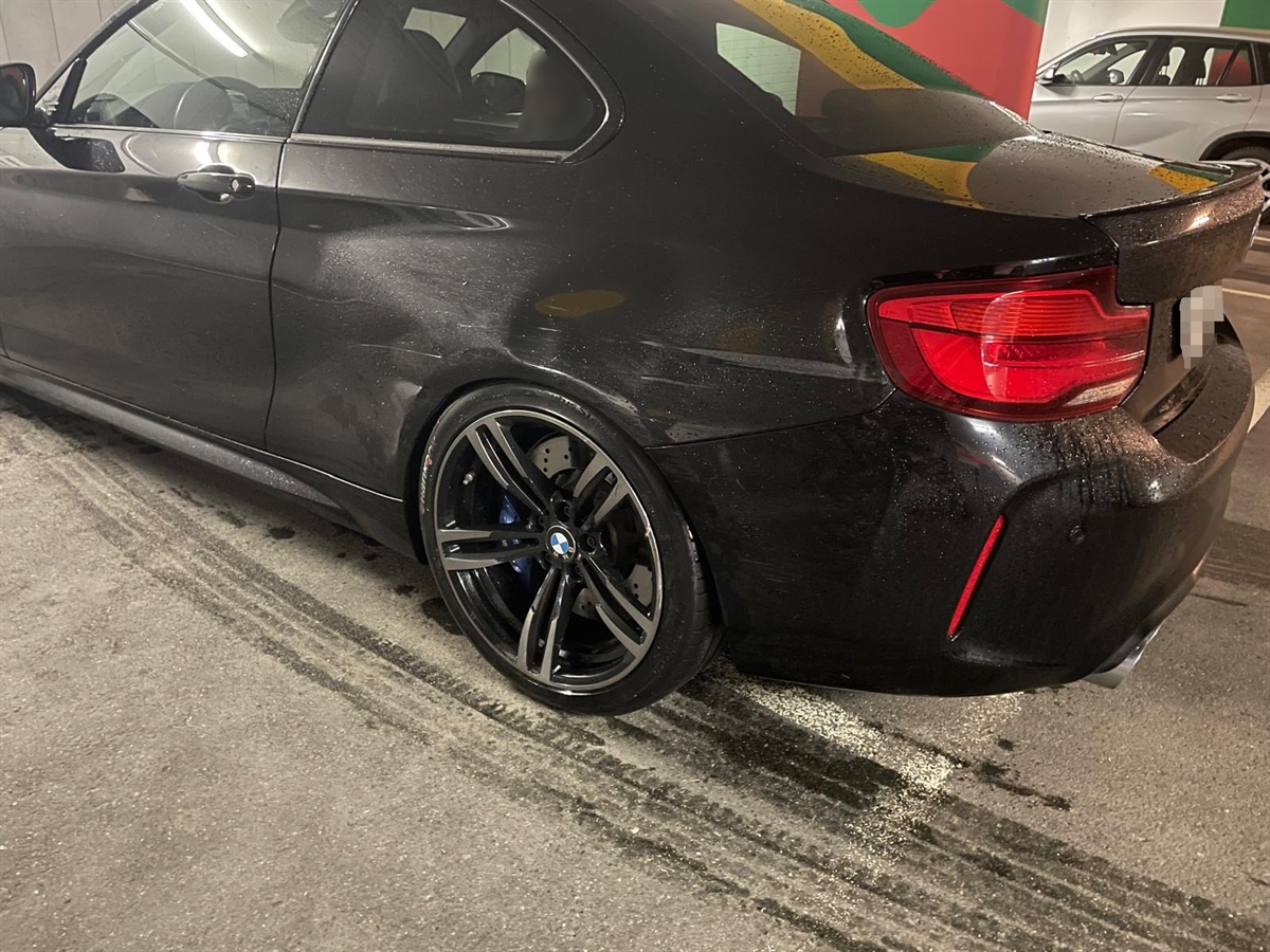Das beschädigte linke Heck des schwarzen BMW's