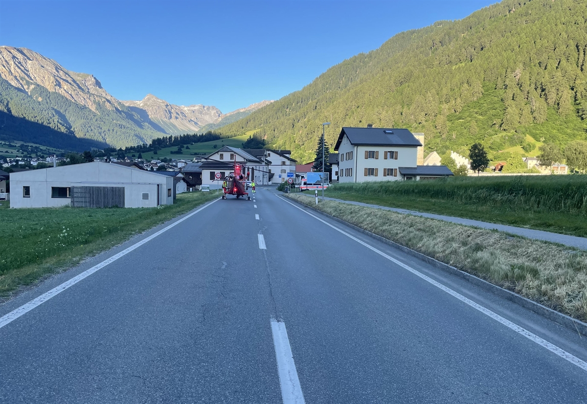 Übersicht der Unfallstelle mit Blick in Richtung Müstair. Es befindet sich gleich am Ortseingang. Auf der linken Spur steht ein REGA-Helikopter. 