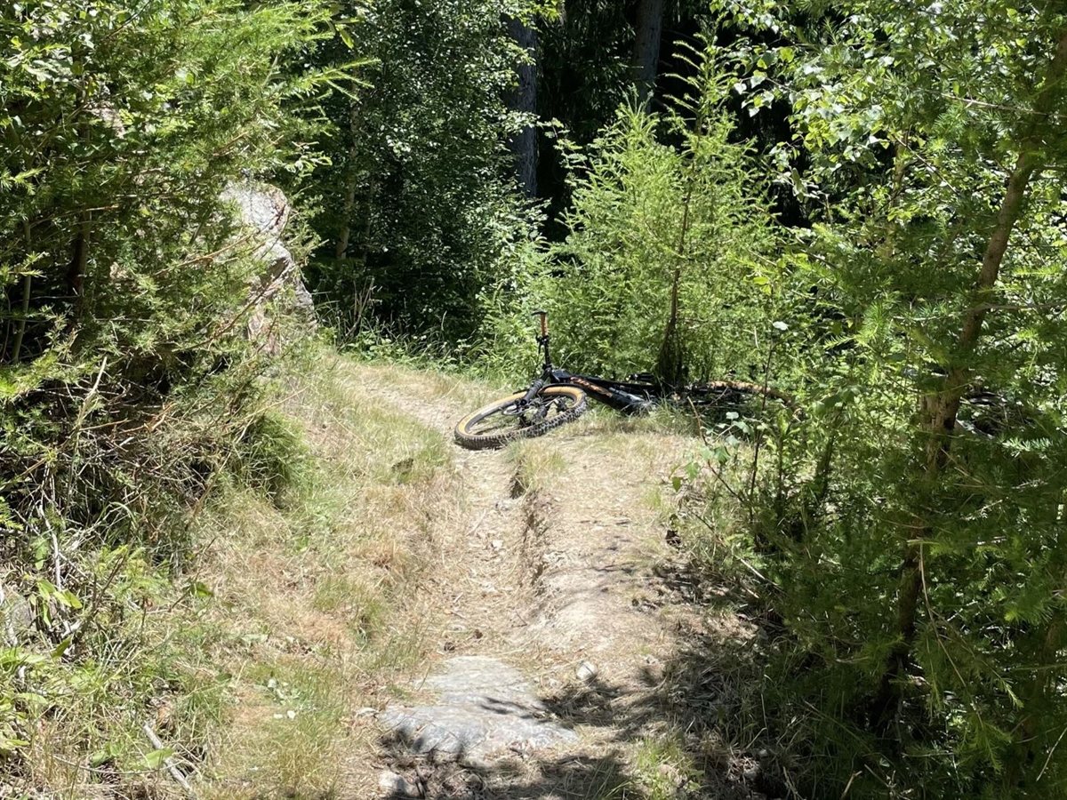 Auf dem Singletrail im Wald liegt das Bike des Verunfallten
