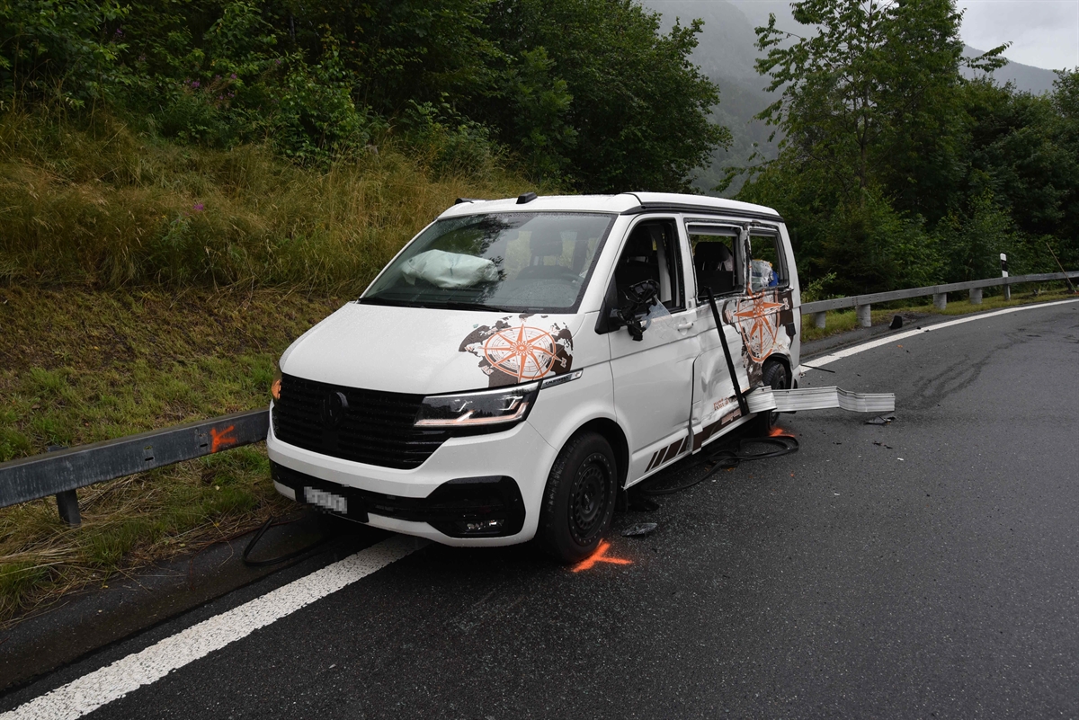 Stark beschädigter Motorwagen steht an der Leitplanke. Die hintere linke Seite ist aufgerissen.