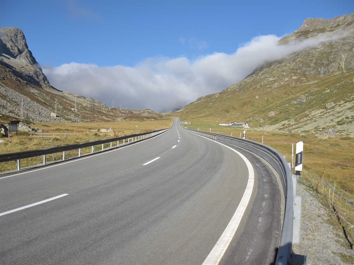 Die Julierstrasse ist beidseitig durch Leitplanken abgegrenzt. Ringsum Bergwelt.