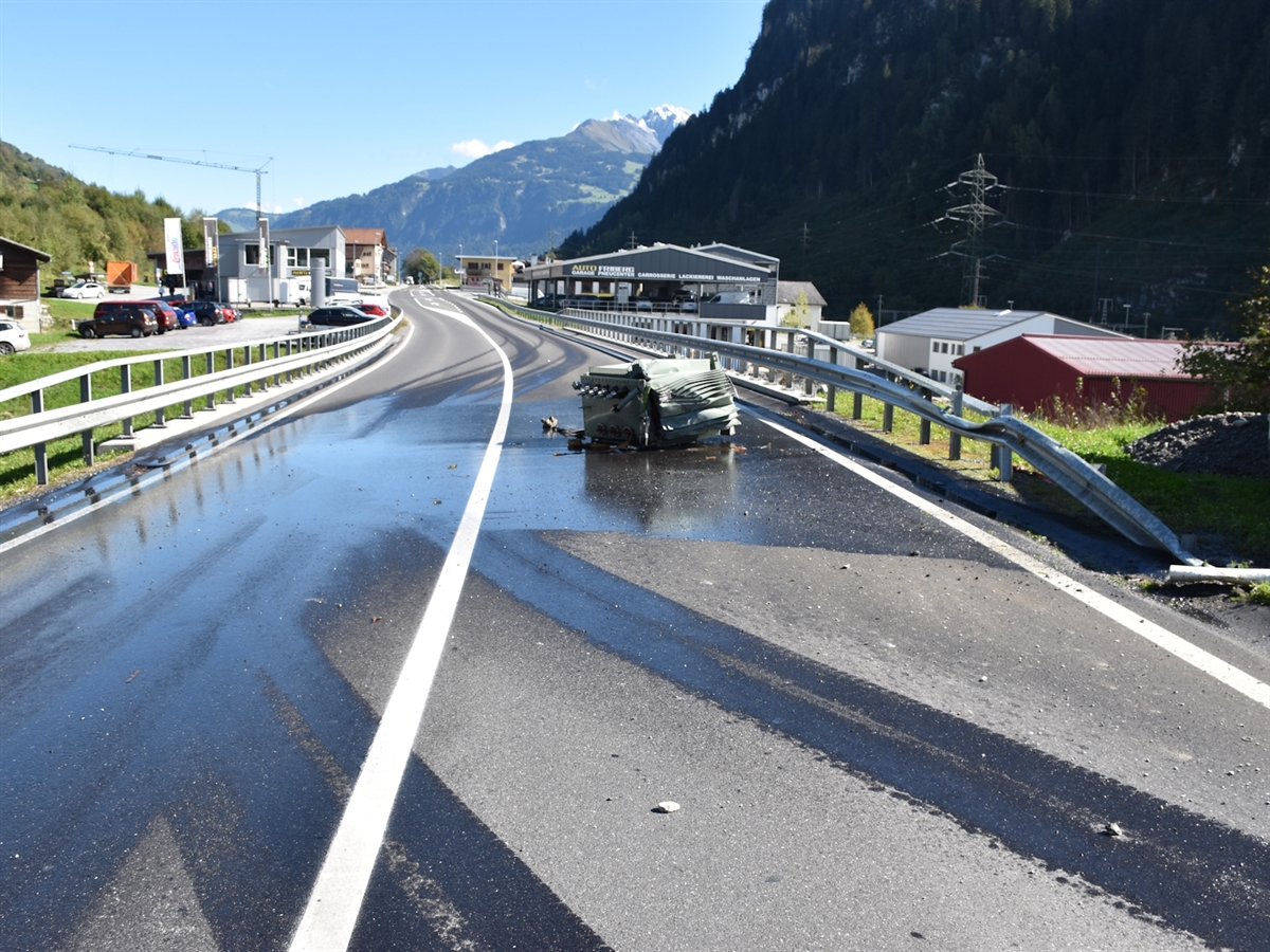 Der verlorene Transformator liegt auf der Fahrspur in Richtung Ilanz. Die Fahrbahn ist mit Öl verschmutzt. Links und rechts wird die Fahrbahn mit einer Leitplanke abgegrenzt.