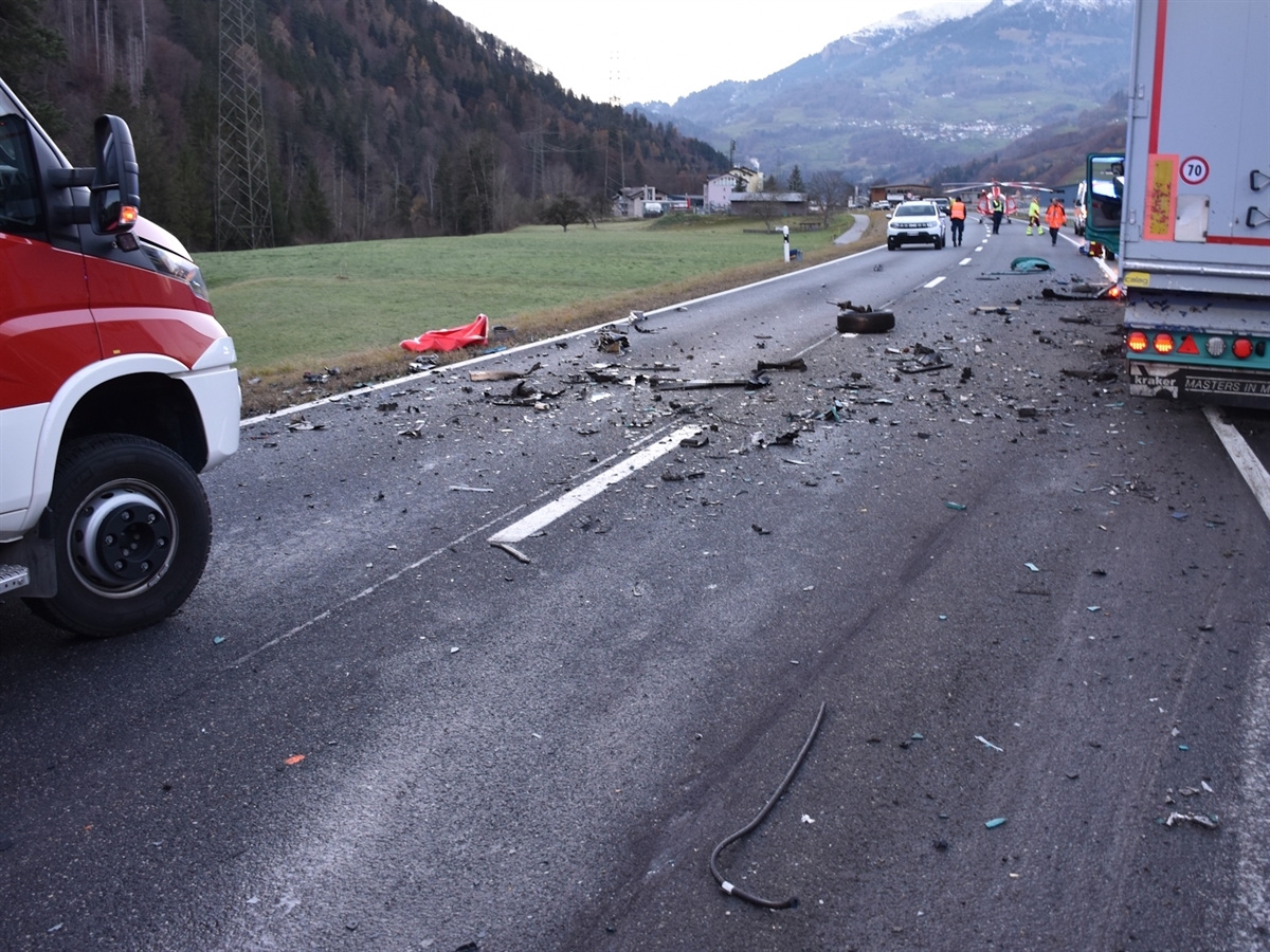 Die mit Fahrzeugteilen bestreute N28. Rechts im Bild das Heck des Sattelmotorfahrzeuges und links die Front eines Feuerwehrautos. Im Hintergrund der Rega-Heli auf der N28 sowie mehrere Einsatzkräfte