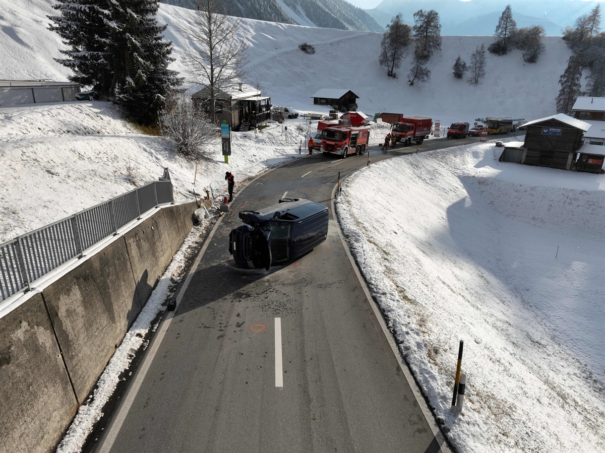 Kleinbus liegt in Seitenlage am Ende einer Kurve inmitten der Hauptstrasse
