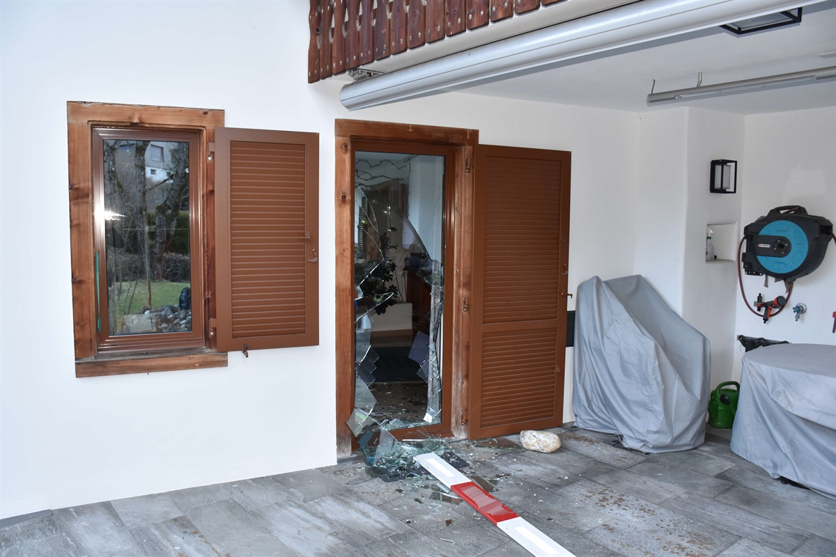 EFH: Übersichtsaufnahme von aussen der Terrassentür mit eingeschlagenem Glas. Eine Holzlatte einer Bauabsperrung liegt unmittelbar vor der Tür auf dem Steinplattenboden.
