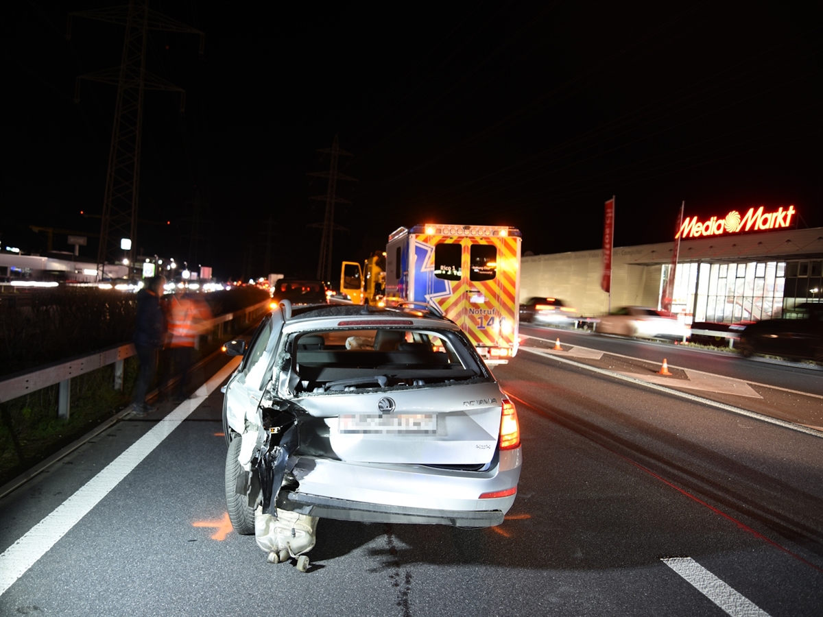 Das Heck vom Auto des 57-Jährigen auf der Überholspur ist linkst total zerstört. Das Heckfenster des Kombis ist eingeschlagen. Links neben dem Auto steht ein Polizist und spricht mit einer Zivilperson. Rechts neben dem Auto steht ein Rettungswagen der Rettung Chur.