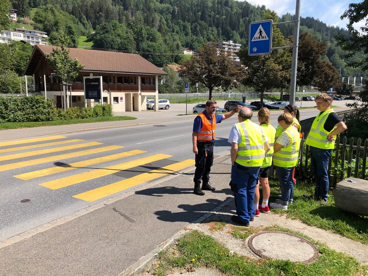 Verkehrsinstruktor mit Gruppe am Fussgängerstreifen
