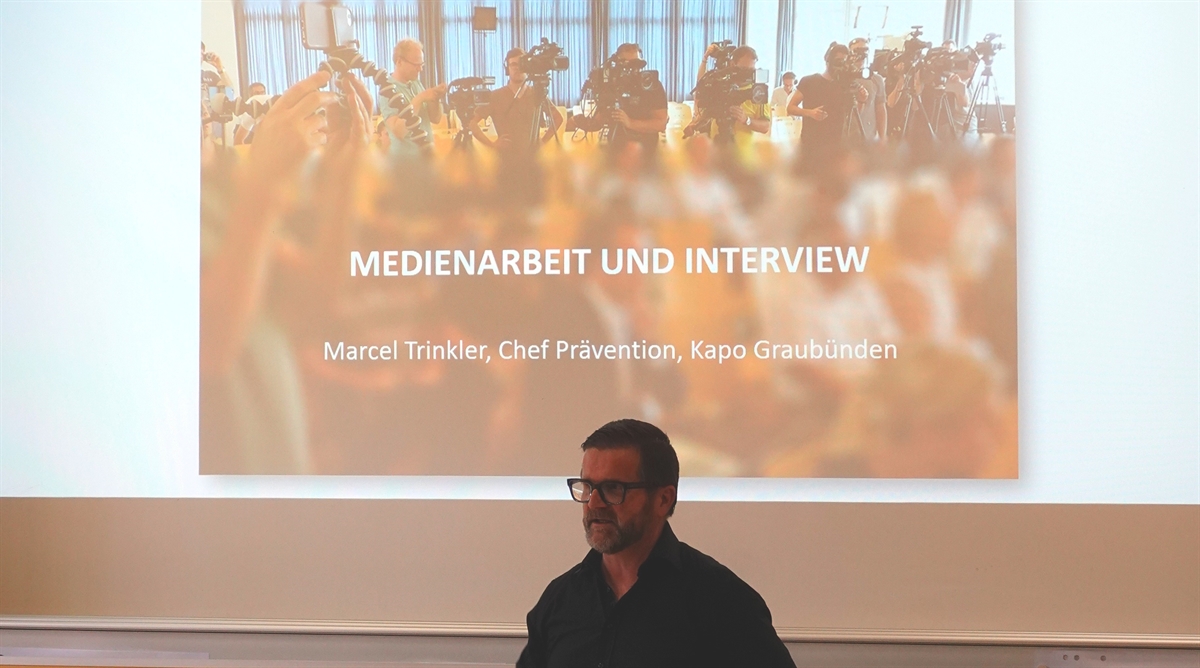 Referent Trinkler mit Präsentation im Hintergrund