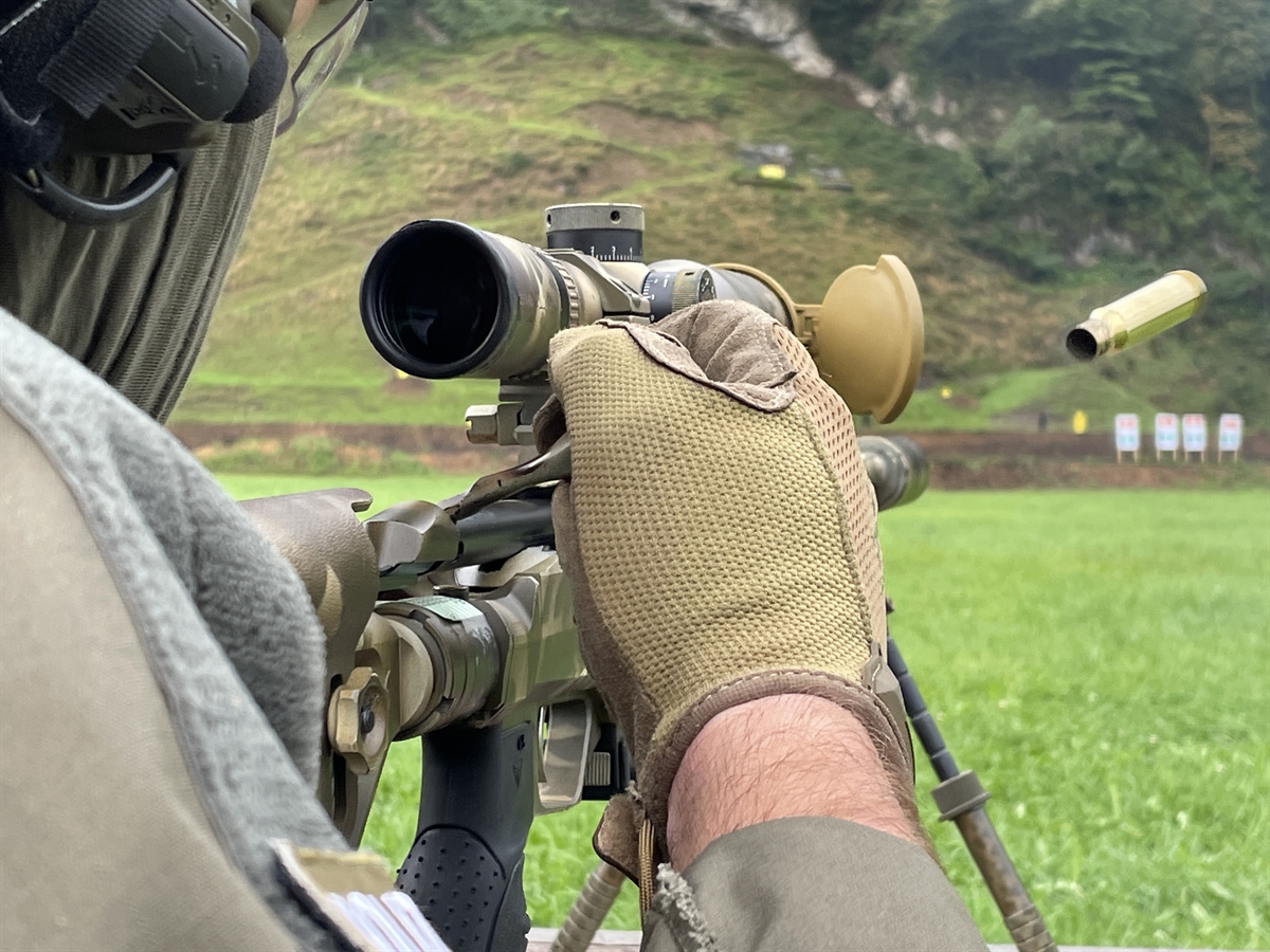 Nahaufnahme von hinten auf ein Sturmgewehr, eine Patronenhülse fliegt rechts aus dem Gewehr