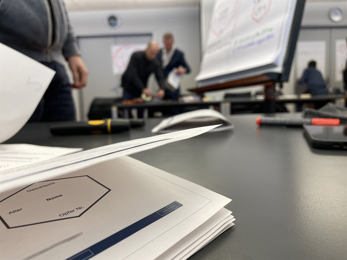 Im Vordergrund ein Soziogramm-Beschrieb und im Hintergrund Kursteilnehmer bei der Übungstätigkeit.