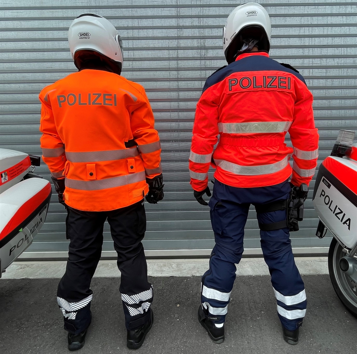 Zwei Polizisten in Motorradbekleidung von hinten. 