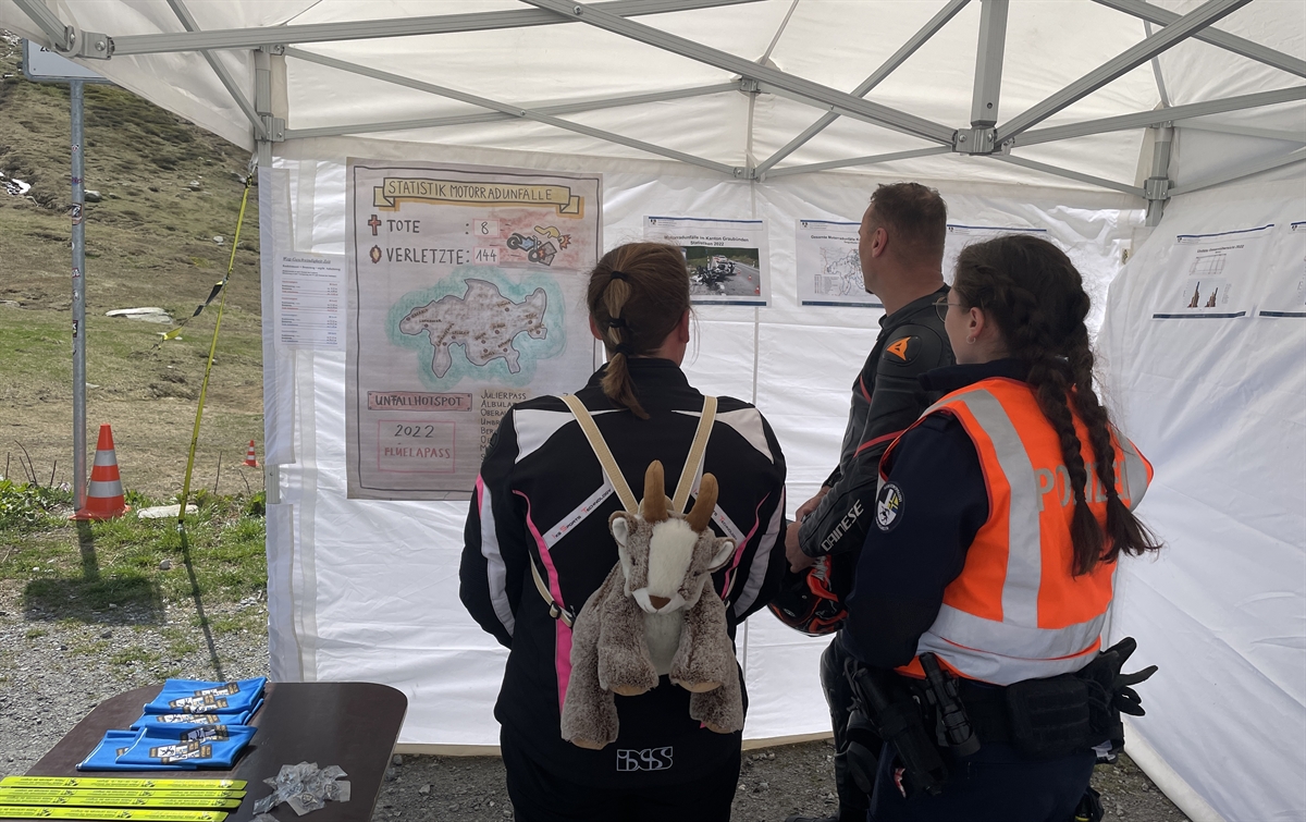 Ein Töfffahrerpaar sieht sich die Plakate im Zelt an