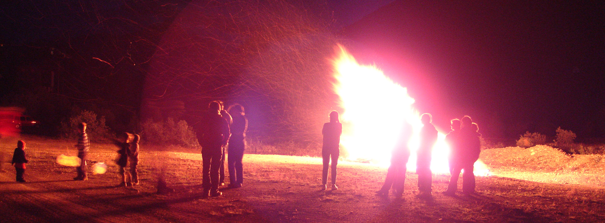 Menschen um ein Feuer im Freien